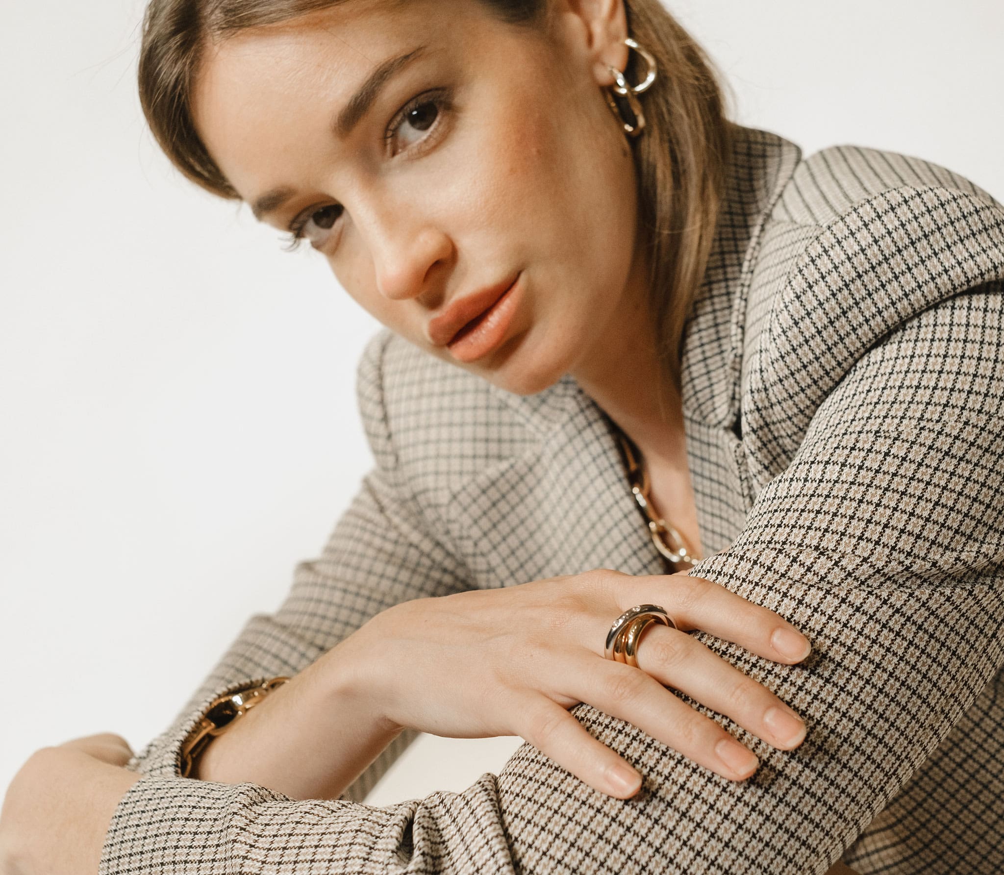 Woman wearing a checkered blazer with a neutral background
